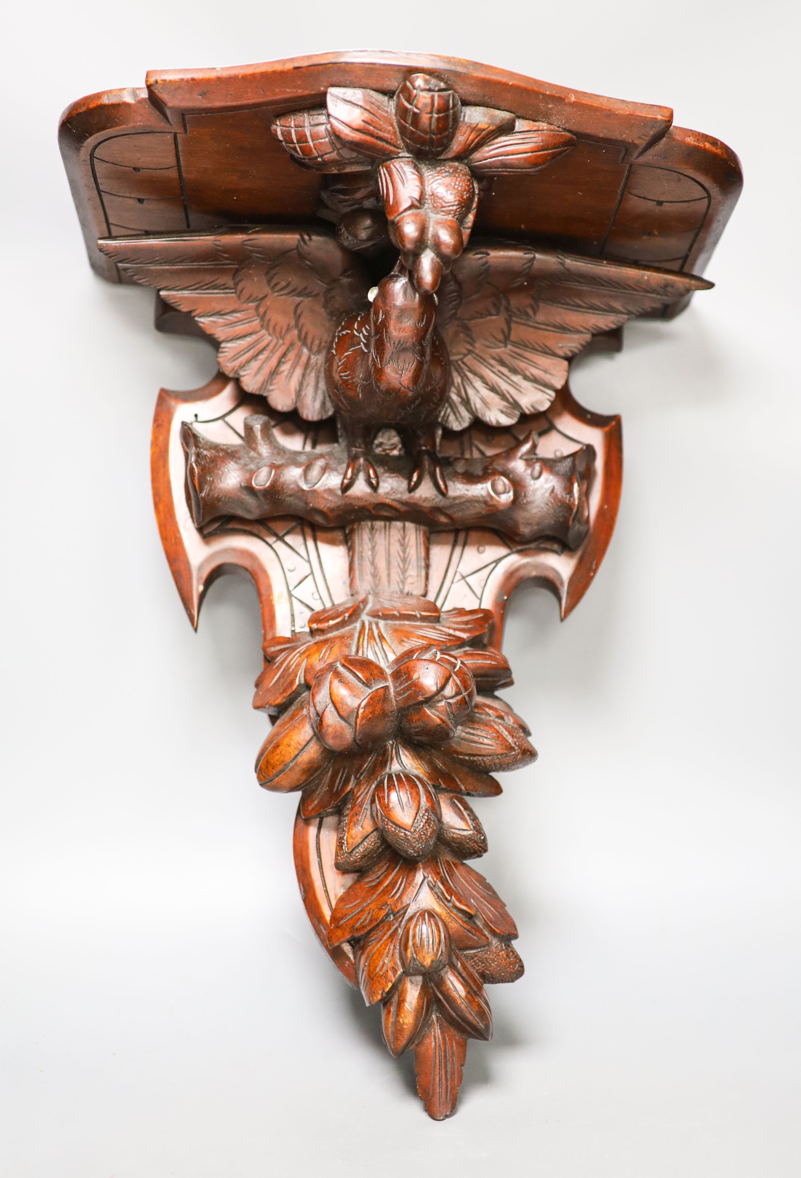 A late 19th century carved mahogany ‘eagle’ wall bracket with glass eyes 51cm